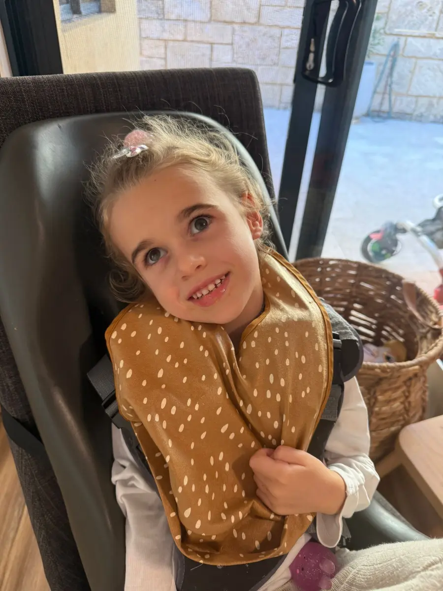 A smiling young Australian child with CDKL5 deficiency disorder having lunch
